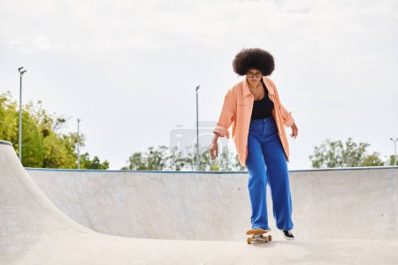 Foto de Una joven afroamericana con el pelo rizado monta hábilmente un monopatín al lado de una rampa en un vibrante parque de skate. - Imagen libre de derechos