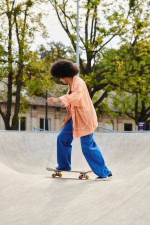 A young African American woman with curly hair glides down a ramp on a skateboard in an outdoor skate park.