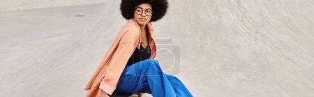 Photo for A young African American woman with an afro confidently rides a skateboard in a vibrant skate park. - Royalty Free Image