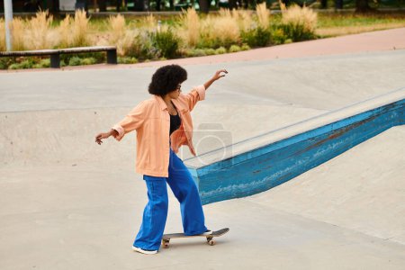 Photo for Young African American woman with curly hair confidently rides her skateboard up the side of a ramp in an outdoor skate park. - Royalty Free Image
