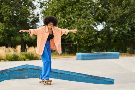 A young African American woman with curly hair rides a skateboard confidently on top of a ramp at an outdoor skate park.