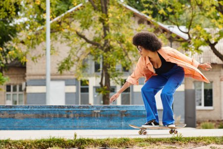 A young African American woman with a skateboard is skateboarding next to a swimming pool in an urban skate park.