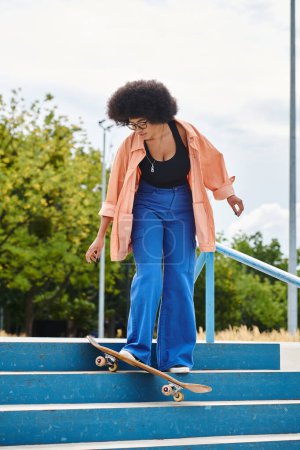 A talented young African American woman with curly hair skillfully rides her skateboard down a flight of stairs at a skate park.