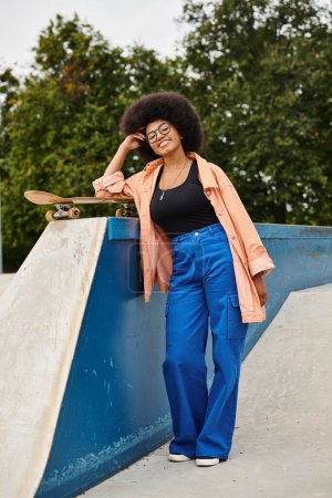 A young African American woman with curly hair skillfully skateboarding next to a ramp in an outdoor skate park.