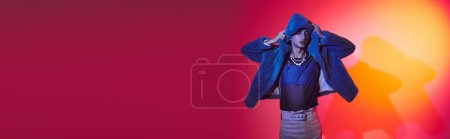 Photo for Chic alluring androgynous man in purple faux fur posing with closed eyes on vibrant backdrop, banner - Royalty Free Image