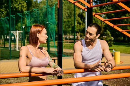Foto de Un hombre y una mujer en ropa deportiva de pie al aire libre, comprometidos con su rutina de entrenamiento, entrenador personal. - Imagen libre de derechos