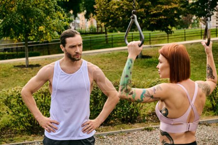 woman in sportswear train together with a personal trainer in a park, showcasing determination and motivation.