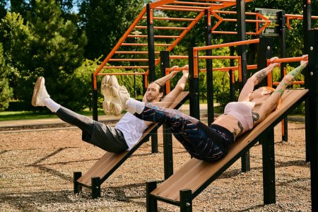 Photo for A man and woman in sportswear lay on benches exercising with a personal trainer, showcasing determination and motivation. - Royalty Free Image