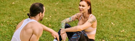 Un hombre y una mujer en ropa deportiva se sientan juntos en la hierba, unidos en su viaje de fitness. Exudan determinación y motivación.