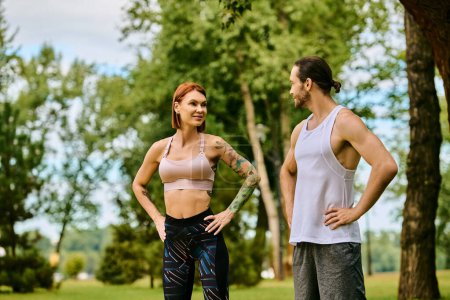 A determined woman in sportswear, working out with a personal trainer in a park.
