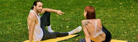Téléchargez les photos : Un homme et une femme déterminés en vêtements de sport assis sur un tapis jaune à l'extérieur - en image libre de droit