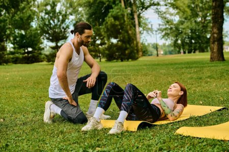 A woman sportswear on a yellow mat outdoors, guided by their personal trainer in a yoga session filled with determination and motivation.