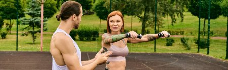 A determined woman in a bra top is holding a dumbbell outdoors, showing motivation and strength during an exercise session led by a personal trainer.