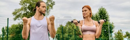 man and woman in sportswear stand together outdoors, exercising with dumbbells