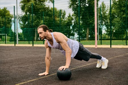 A man in sportswear performing push ups with a ball under the guidance of a personal trainer, showcasing determination and motivation.