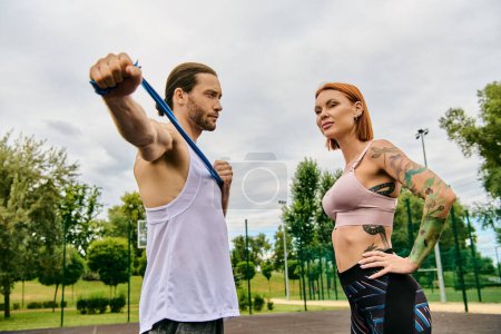 A woman in sportswear, with a personal trainer, engaging in outdoor exercises with determination and motivation.