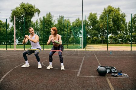 A personal trainer motivates a woman as they work out with resistance bands