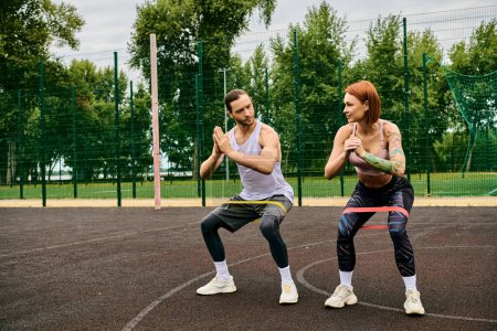 A woman in sportswear work out under the guidance of personal trainer on a vibrant court, showcasing determination and motivation.