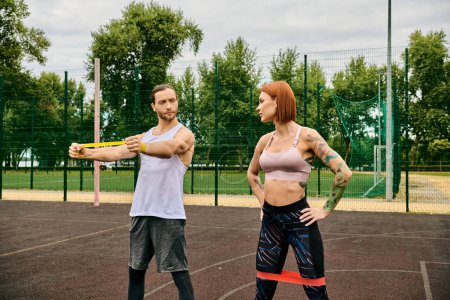 A determined woman, in sportswear outdoors with their personal trainer.