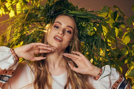 Téléchargez les photos : Une jeune mavka ornée d'une couronne de feuilles dans un décor de studio, dégageant une aura de fée et de fantaisie. - en image libre de droit