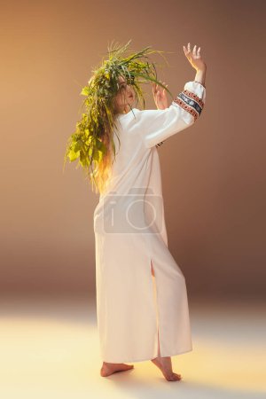 Une jeune femme en robe blanche orne sa tête d'une couronne végétale, incarnant une esthétique fantaisiste et féerique dans un décor de studio.
