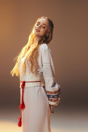 Une jeune femme envoûtante ornée d'une robe blanche aux pompons rouges complexes, aux vibrations féeriques et fantastiques dans un décor studio.