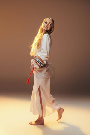 Photo for Young mavka in a white dress strikes a pose in a studio setting, embodying fairy and fantasy elements. - Royalty Free Image