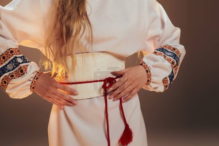Eine junge Frau in einem traditionellen weißen Kleid mit langen Haaren, die eine ätherische und märchenhafte Präsenz in einem Studio-Setting ausstrahlt.