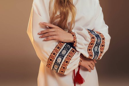 Une jeune mavka ornée d'une robe blanche avec un pompon rouge saisissant, respirant un air de mystique dans un décor de studio.