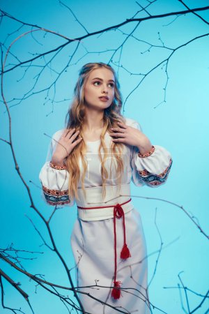 Una joven con un vestido blanco se levanta con gracia frente a un majestuoso árbol, encarnando elementos de hadas y fantasía en un entorno de estudio.