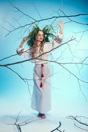 Una joven vestida con un traje tradicional, adornada con una corona de hadas y fantasía, se levanta con gracia frente a las ramas.