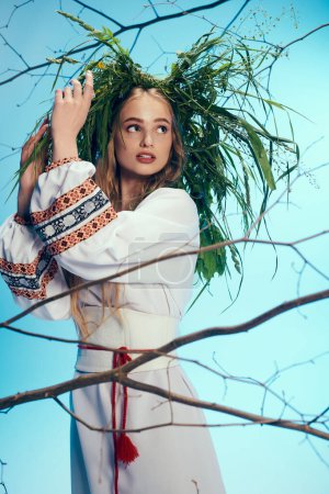 Una joven mavka vestida con traje tradicional se para ante un majestuoso árbol, llevando una corona en la cabeza..