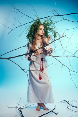 Eine junge Mavka im weißen Kleid balanciert in einem Atelier zart eine Pflanze auf ihrem Kopf und verkörpert dabei märchenhafte Anmut.