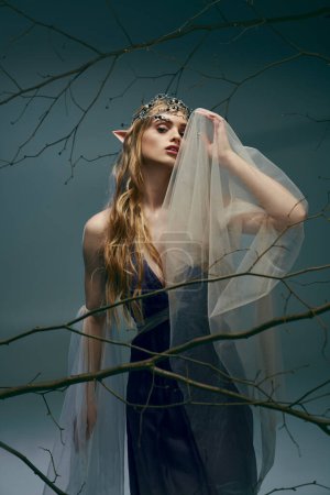 A young woman in a dress resembling an elf princess, adorned with a veil, exuding an air of fantasy and enchantment in a studio setting.