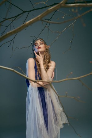 Una joven con un vestido azul y blanco se levanta con gracia junto a un árbol en un entorno de cuento de hadas.