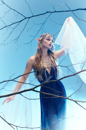 Une jeune femme dans une robe bleue fluide, ressemblant à une princesse elfe, se tient gracieusement au sommet d'un arbre d'une manière fantaisiste et féerique.
