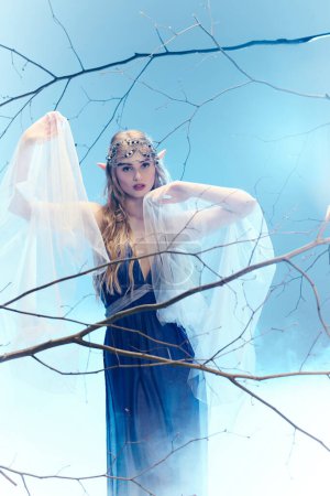Une jeune femme exsude une magie féerique dans une robe bleue et un voile blanc dans un décor studio fantaisiste.