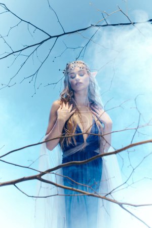 Une jeune femme en robe bleue se tient gracieusement devant un arbre majestueux dans un décor inspiré de contes de fées.