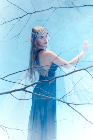 A young woman in a blue dress stands gracefully in a tree, embodying the essence of a fairy princess in a mystical forest.