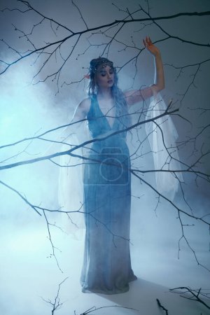 A young woman in a blue dress stands gracefully in a foggy setting, embodying the essence of a fairy-tale elf princess.