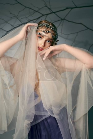 A young woman in a dress with a veil adorning her head looks like a fairy princess in a fantasy setting.
