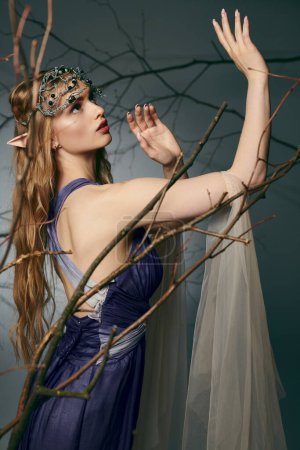 Une jeune femme dans une robe bleue frappante se tient élégamment devant un arbre majestueux dans un cadre de studio, incarnant une princesse elfe.