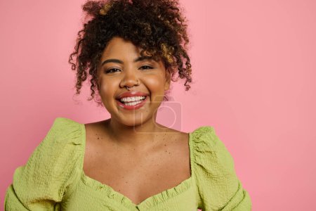 Foto de Mujer afroamericana, con estilo en amarillo, sonriendo con gracia. - Imagen libre de derechos
