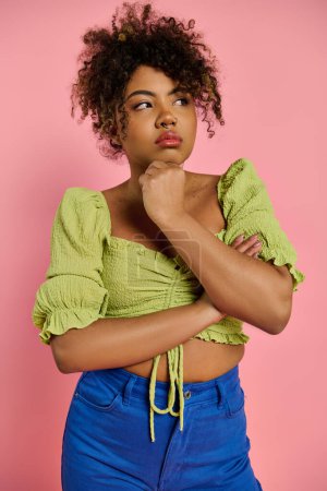 Eine schöne Afroamerikanerin, emotional und stilvoll, posiert in einem gelben Oberteil vor einem lebendigen Hintergrund.
