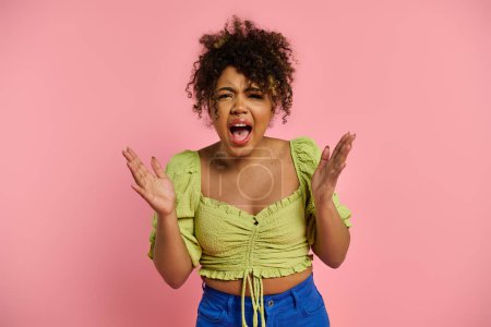 Stylish African American woman makes a humorous expression in front of vibrant pink backdrop.