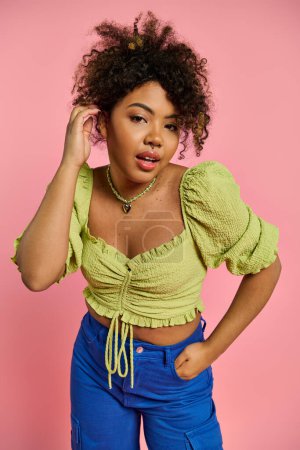 Eine modische Afroamerikanerin posiert in lebendiger Kleidung vor farbenfroher Kulisse.