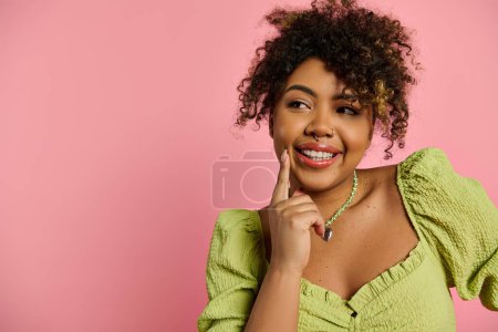 Stylish African American woman posing on vibrant backdrop in a yellow dress.