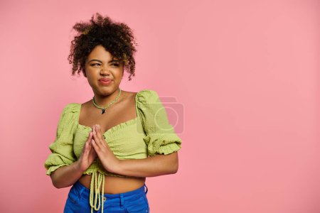 Stylish African American woman posing in yellow top and blue pants against vibrant backdrop.