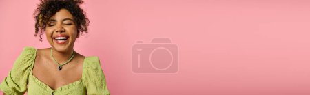 Photo for African American woman in yellow top laughs with eyes closed. - Royalty Free Image