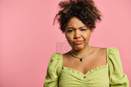 A stylish African American woman in a yellow top poses on a vibrant backdrop.
